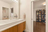 This modern bathroom features a sleek, integrated sink with a minimalist faucet and wooden cabinetry.