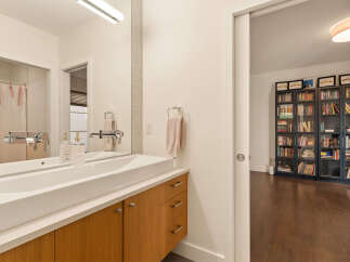This modern bathroom features a sleek, integrated sink with a minimalist faucet and wooden cabinetry.