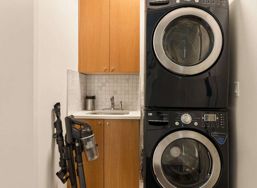 This laundry room features a sleek, stacked LG washer and dryer set in a modern black finish, perfect for maximizing space.