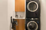 This laundry room features a sleek, stacked LG washer and dryer set in a modern black finish, perfect for maximizing space.