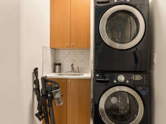 This laundry room features a sleek, stacked LG washer and dryer set in a modern black finish, perfect for maximizing space.