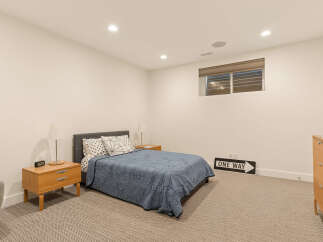 Discover comfort and style in this inviting bedroom, featuring a plush bed with decorative pillows and a unique blue quilt.