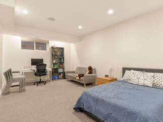 This versatile room features a comfortable bed, a cozy sofa, and a dedicated workspace with a desk and office chair.