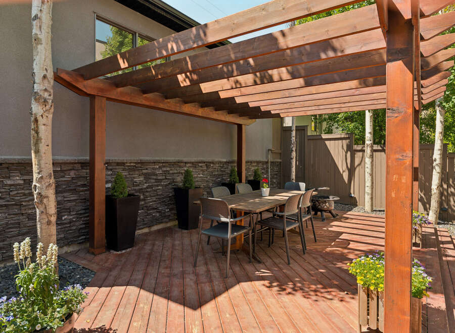 Enjoy outdoor living under this stunning wooden pergola, perfect for al fresco dining and entertaining.