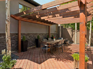 Enjoy outdoor living under this stunning wooden pergola, perfect for al fresco dining and entertaining.