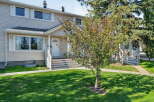 Charming townhouse with a welcoming front entrance, featuring a white door and steps leading up to the porch.