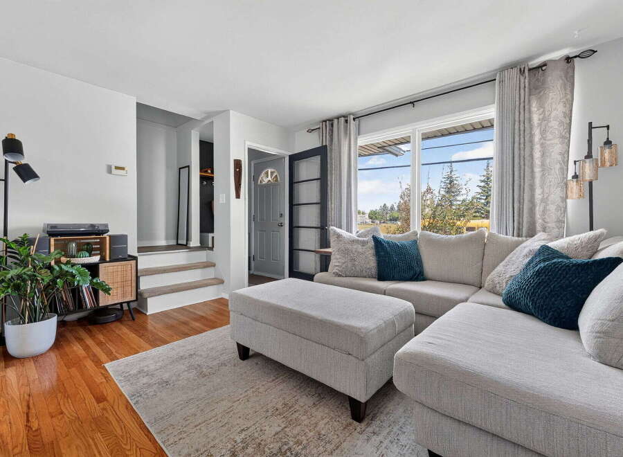 Step into this inviting living room, featuring a spacious sectional sofa perfect for gatherings and a stylish ottoman for added comfort.