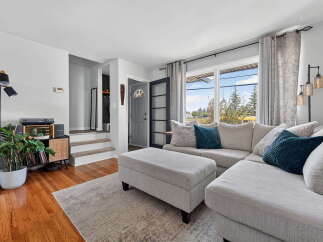 Step into this inviting living room, featuring a spacious sectional sofa perfect for gatherings and a stylish ottoman for added comfort.