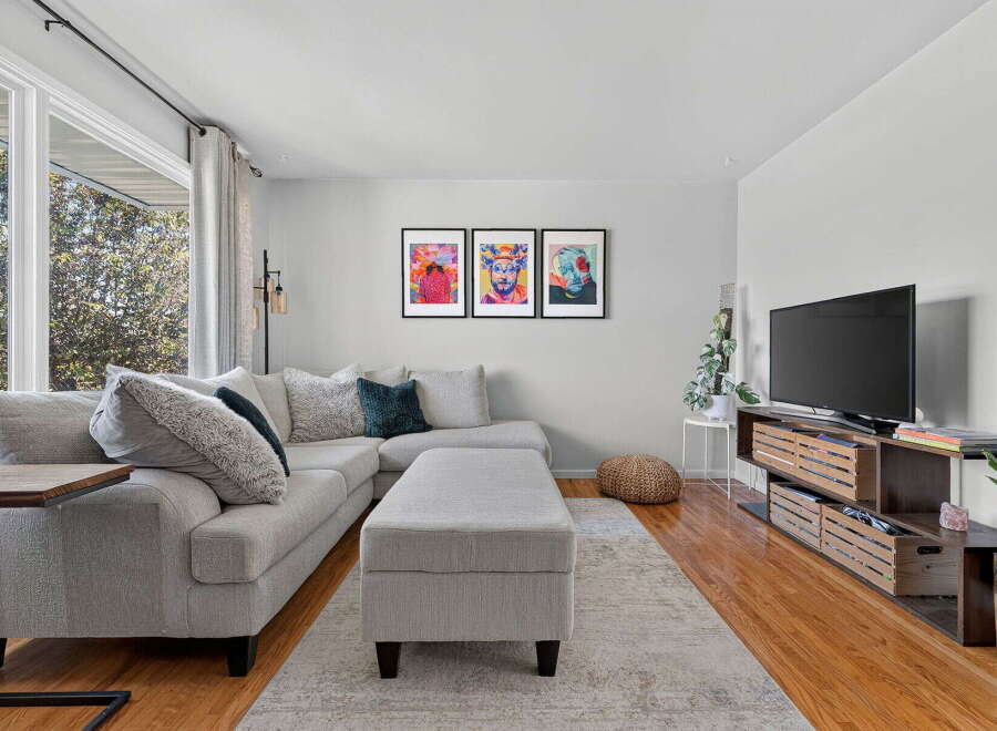 This living room boasts a comfortable sectional sofa with plush throw pillows, perfect for relaxing.