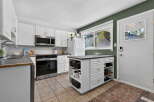 Discover this charming kitchen featuring white cabinetry, a stainless steel microwave, and a sleek oven.