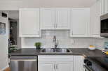 This kitchen features a sleek stainless steel dishwasher and a double basin sink, perfect for any home chef.