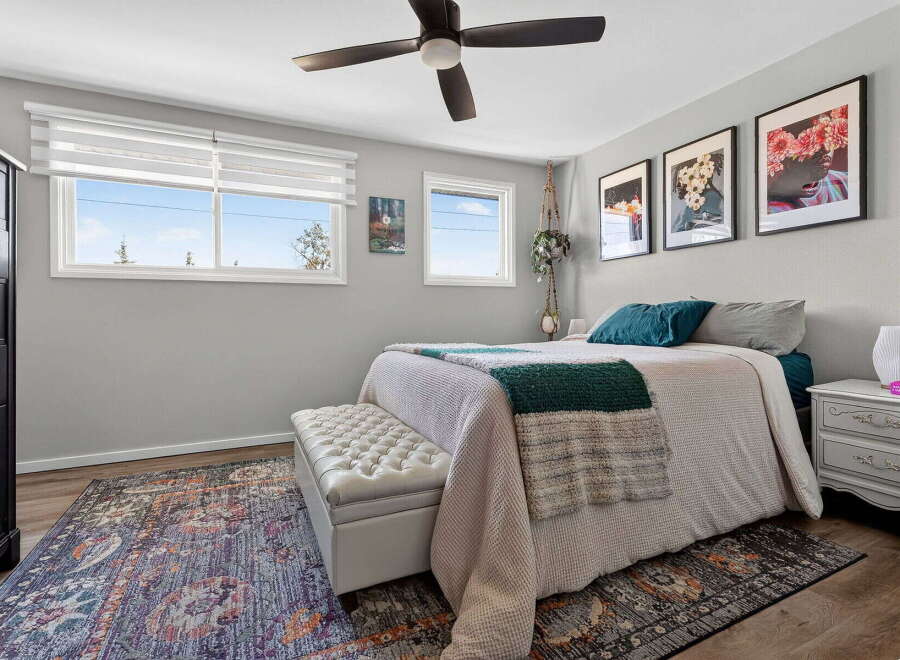 This inviting bedroom features a comfortable queen-size bed adorned with plush pillows and a cozy throw blanket, perfect for relaxation.