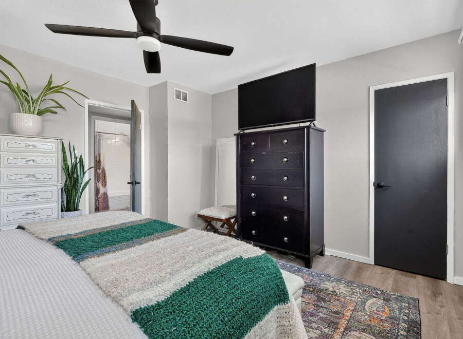 This bedroom offers a comfortable and stylish retreat, featuring a plush bed adorned with a cozy striped blanket.