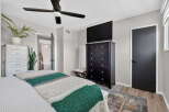 This bedroom offers a comfortable and stylish retreat, featuring a plush bed adorned with a cozy striped blanket.