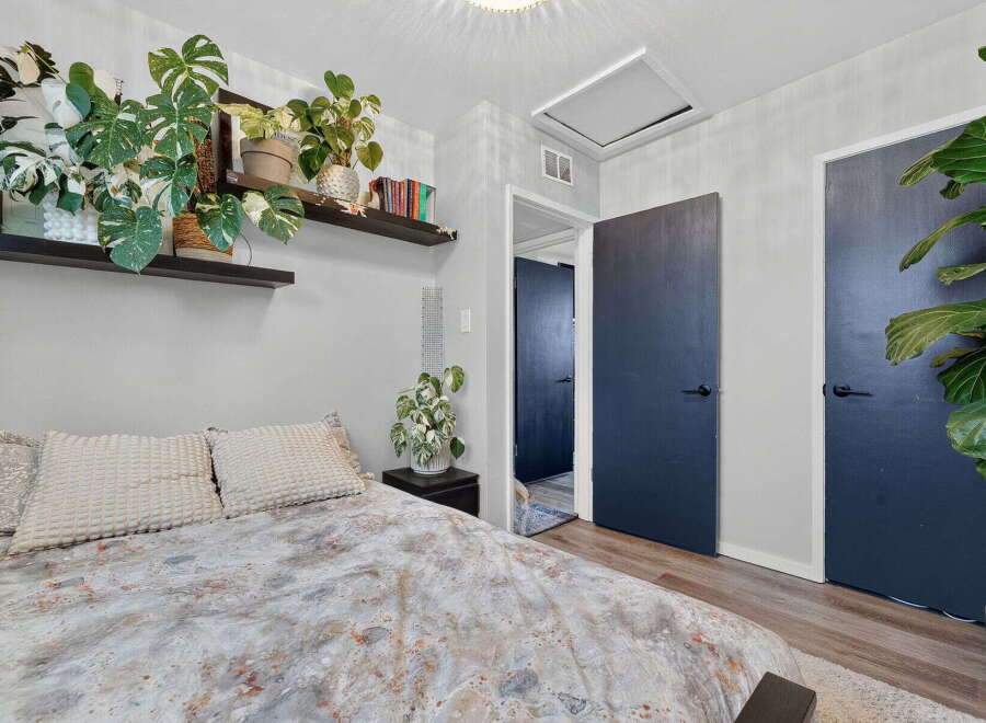 This bedroom offers a serene retreat with a comfortable bed adorned with plush pillows and a unique patterned duvet.