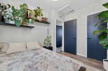 This bedroom offers a serene retreat with a comfortable bed adorned with plush pillows and a unique patterned duvet.