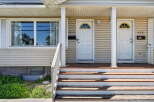 Charming duplex featuring two separate entrances, each with a welcoming porch and a distinctive arched window above the door.