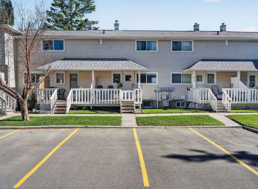 Discover comfortable living in this charming townhouse complex, featuring a well-maintained exterior with neutral siding and a pitched roof.