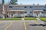 Discover comfortable living in this charming townhouse complex, featuring a well-maintained exterior with neutral siding and a pitched roof.