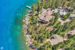 Experience luxury lakeside living in this stunning property featuring a sprawling estate with multiple buildings, a private dock, and direct access to crystal-clear turquoise waters.