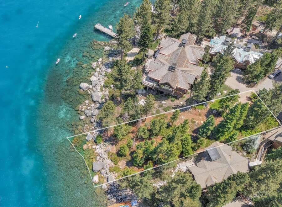 Experience luxury lakeside living in this stunning property featuring a sprawling estate with multiple buildings, a private dock, and direct access to crystal-clear turquoise waters.