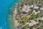 Experience luxury lakeside living in this stunning property featuring a sprawling estate with multiple buildings, a private dock, and direct access to crystal-clear turquoise waters.