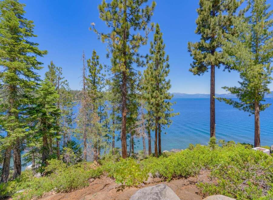 Experience breathtaking lake views from this stunning property, nestled amidst mature pine trees.
