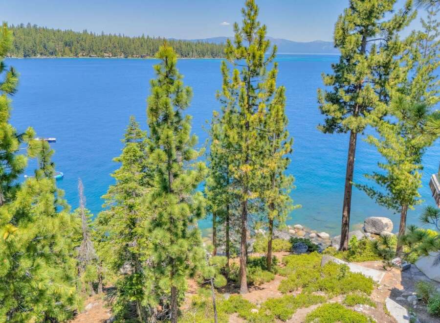 Experience breathtaking lake views from this stunning property, nestled amidst towering pine trees.