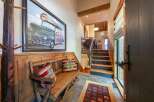 Step into this charming entryway featuring a rustic wooden bench adorned with decorative pillows, perfect for a cozy welcome.