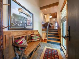 Step into this charming entryway featuring a rustic wooden bench adorned with decorative pillows, perfect for a cozy welcome.