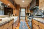 Experience rustic charm in this beautifully appointed kitchen, featuring warm wood cabinetry and a farmhouse sink.