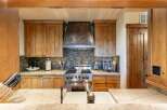 Experience rustic charm in this beautifully appointed kitchen, featuring custom wood cabinetry and a striking copper range hood.