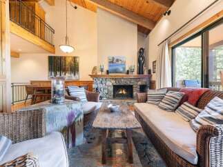 Experience cozy living in this inviting living room, featuring a magnificent stone fireplace as the centerpiece.