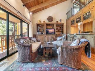 Experience rustic charm in this inviting living room, featuring a cozy wicker sofa and armchair perfect for relaxation.