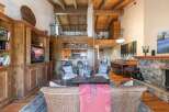 Experience rustic charm and spacious living in this stunning mountain home, featuring a grand stone fireplace and a soaring wood-beamed ceiling.
