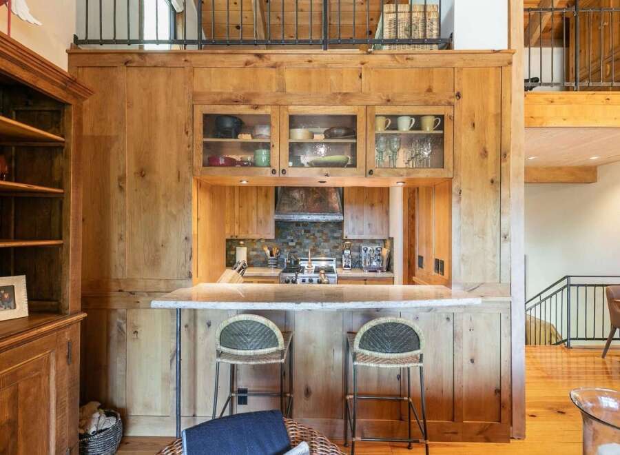 Experience rustic charm in this kitchen featuring warm, natural wood cabinetry and a stone backsplash.