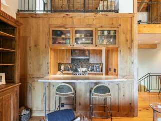 Experience rustic charm in this kitchen featuring warm, natural wood cabinetry and a stone backsplash.