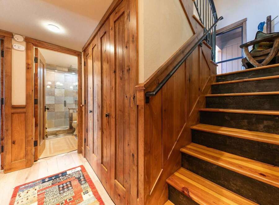 Step into a rustic charm with this inviting hallway featuring warm wood paneling and a cozy rug.