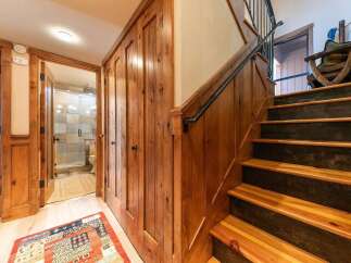 Step into a rustic charm with this inviting hallway featuring warm wood paneling and a cozy rug.
