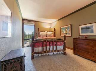 Experience rustic charm in this cozy bedroom, featuring a unique log bed and a picturesque window with stunning forest views.