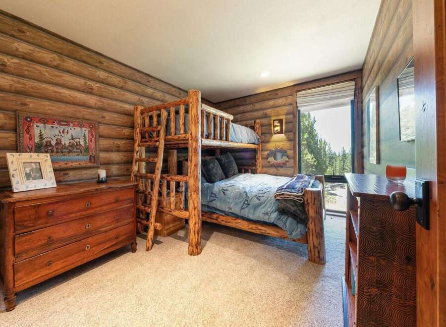 Experience rustic charm in this cozy cabin-style bedroom, featuring a sturdy log bunk bed perfect for family or guests.