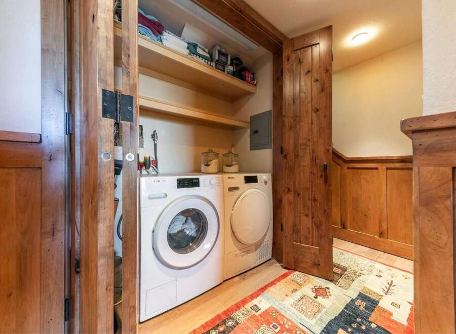 Discover the convenience of a dedicated laundry space featuring a stacked Miele washer and dryer.