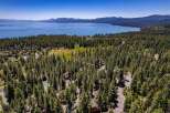 Experience the ultimate mountain lifestyle with this stunning aerial view of a property nestled amidst a dense pine forest.