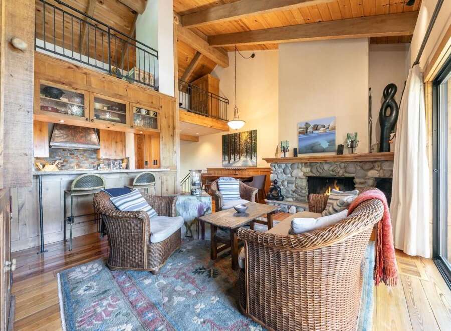 Experience rustic charm in this inviting living space, featuring a grand stone fireplace as the centerpiece.