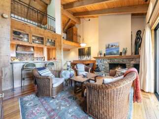 Experience rustic charm in this inviting living space, featuring a grand stone fireplace as the centerpiece.