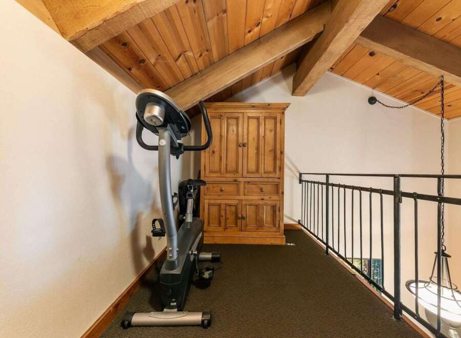 This charming loft space features a dedicated workout area with an exercise bike, perfect for maintaining your fitness routine.
