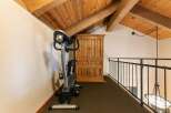 This charming loft space features a dedicated workout area with an exercise bike, perfect for maintaining your fitness routine.