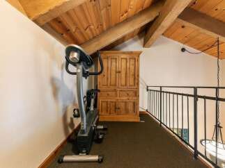 This charming loft space features a dedicated workout area with an exercise bike, perfect for maintaining your fitness routine.