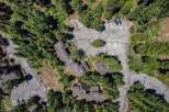 Discover this stunning aerial view showcasing a cluster of modern townhomes nestled amidst a dense forest.