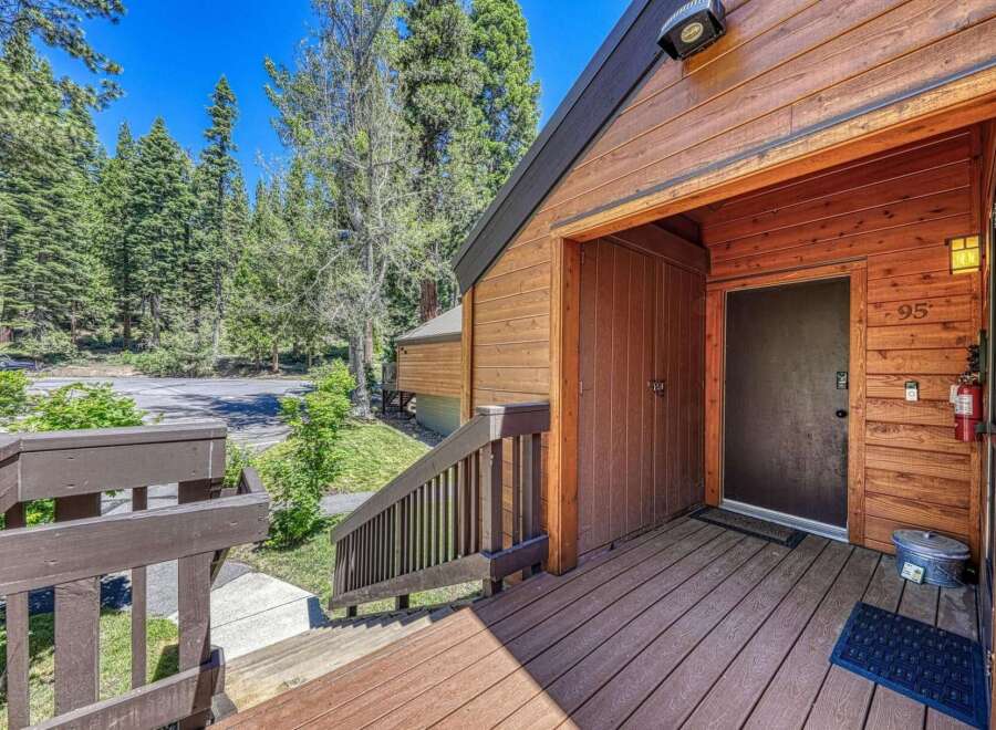 Experience the charm of this mountain retreat, featuring a welcoming wooden deck leading to the entrance.